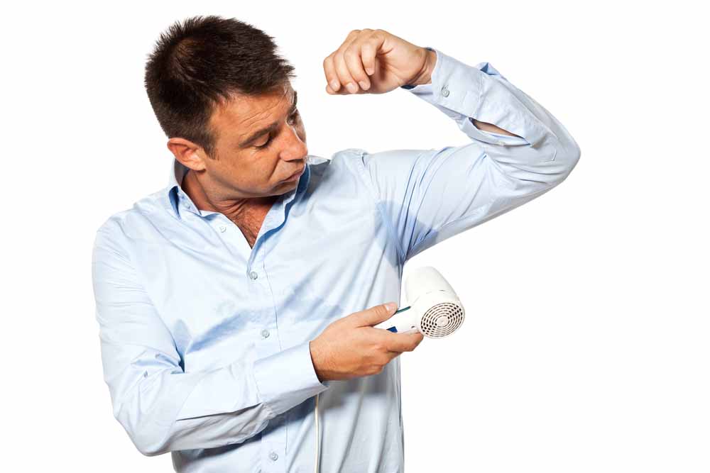 Мужчина сушит мокрые подмышки