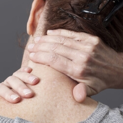 Пациентка держится за шею Девушка держится за шею