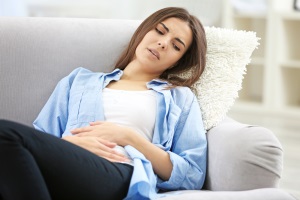 Девушка лежит из-за недомогания Девушка лежит из-за боли