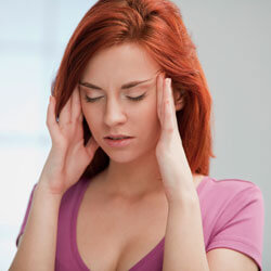 Девушка в футболке держится за голову Девушка в розовом держится за голову