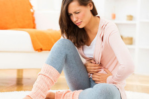 Девушка скрючилась от боли Девушка скрутилась от боли