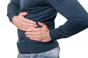 Мужчина держится за бок Мужчина держится за селезенку