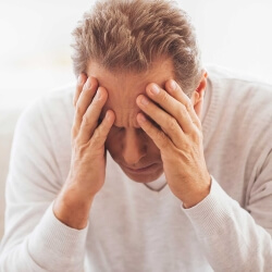 Мужчина держится за виски Мужчина держится за голову