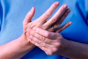 Разминает руку Массирует руку