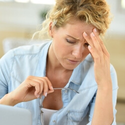 Смотрит в ноутбук и держит голову Смотрит в ноутбук