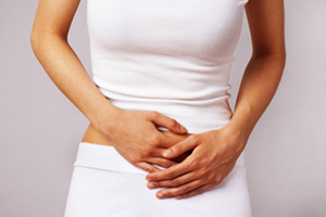 Женщина держится за низ живота Женщина схватилась за низ живота