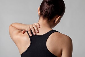 Женщина держится за шею Женщина держится за шейку