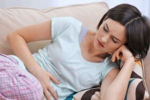 Женщина скрутилась от недомогания Женщина скрутилась от боли